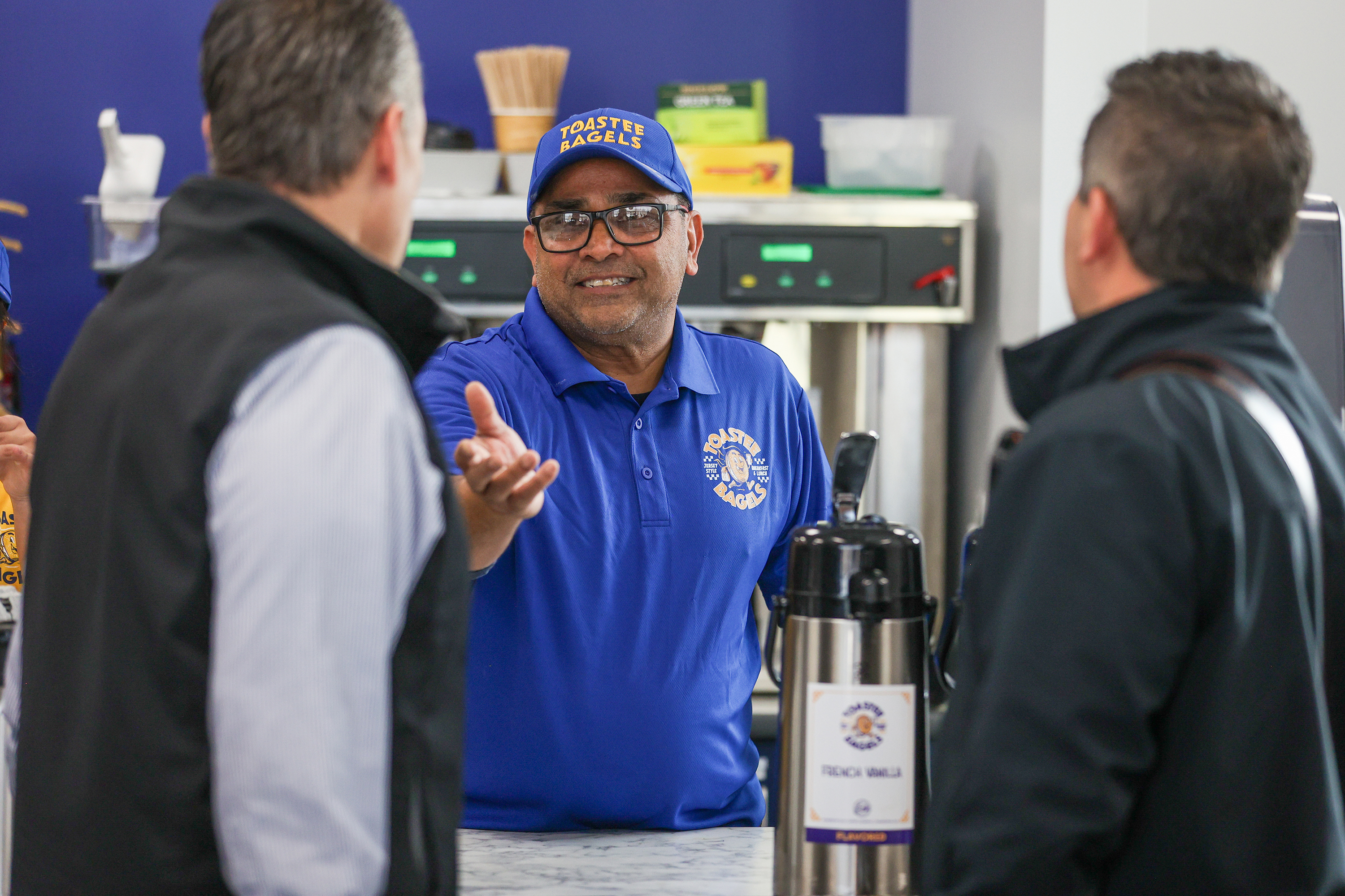 Toastee Bagels owner Neil Patel chats with customers during a...
