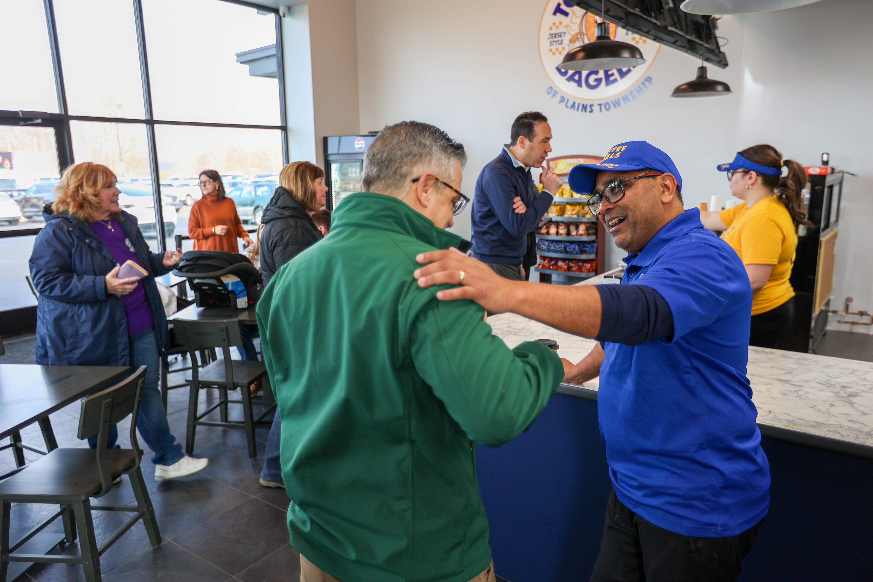 Toastee Bagels owner Neil Patel chats with customers during a...