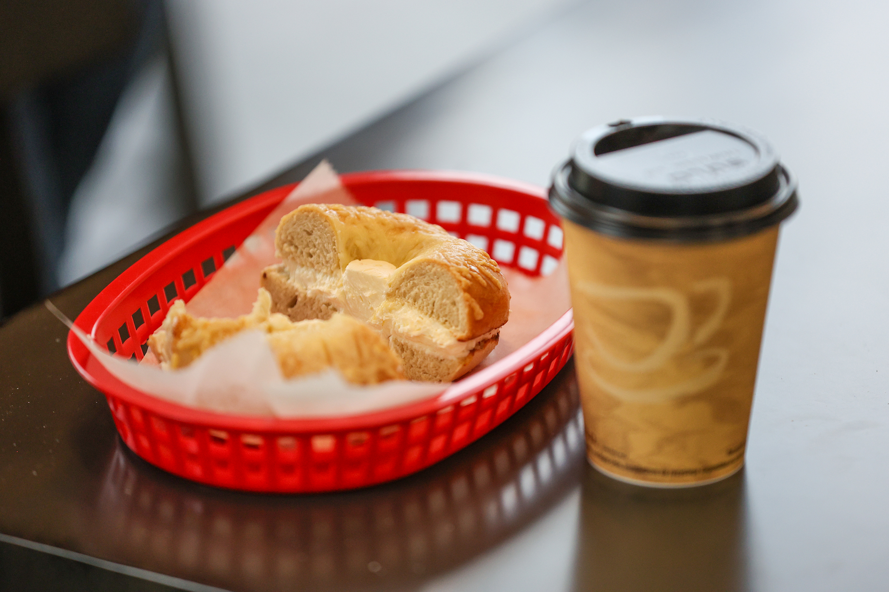 A bagel with cream cheese and a coffee from Toastee...