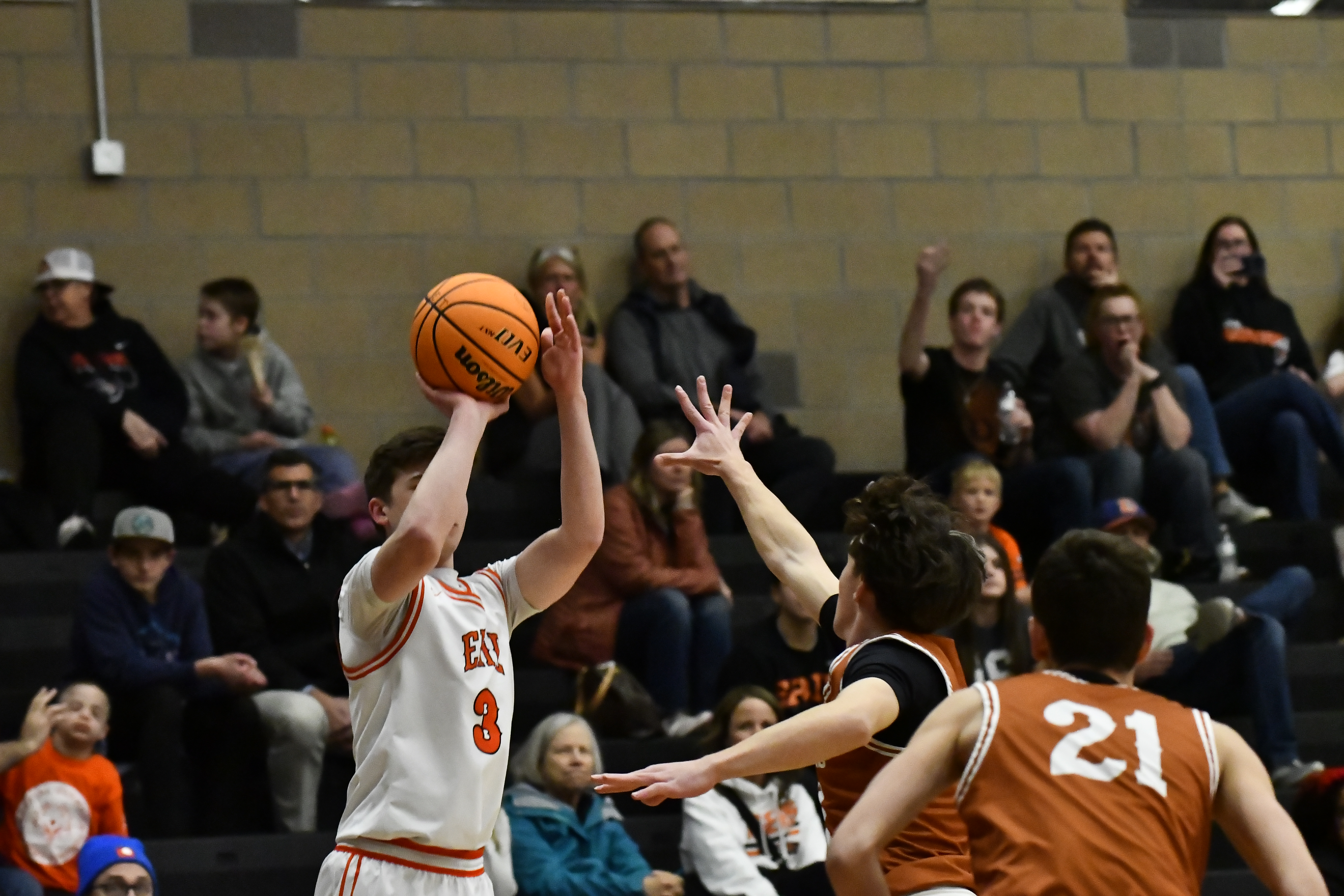 Erie's Christopher Smith takes a 3-pointer with pressure from Mead's...