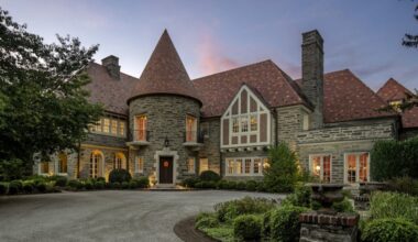 The fieldstone house for sale for $7.9 million on Creighton Road in Lower Merion includes an entrance tower with a chandelier and winding staircase.