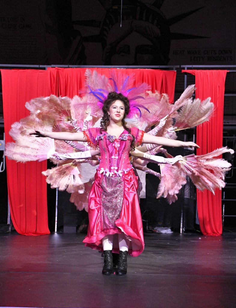 students performing in costume on stage