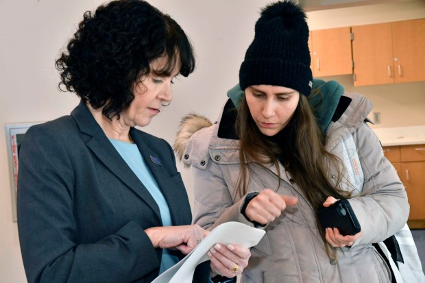 DCCC President Dr. Marta Yera Cronin, left, greets and helps an unidentified student at Delaware County Community College's new Southeast Center in Drexel Hill. (COURTESY OF DCCC)