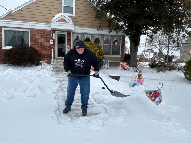 The first big storm in years dropped more than 5 inches of snow and ice in Delaware County on Sunday. On Monday, Bob Smalley of Folsom clears his walkway before heading to work. (PETE BANNAN-DAILY TIMES)