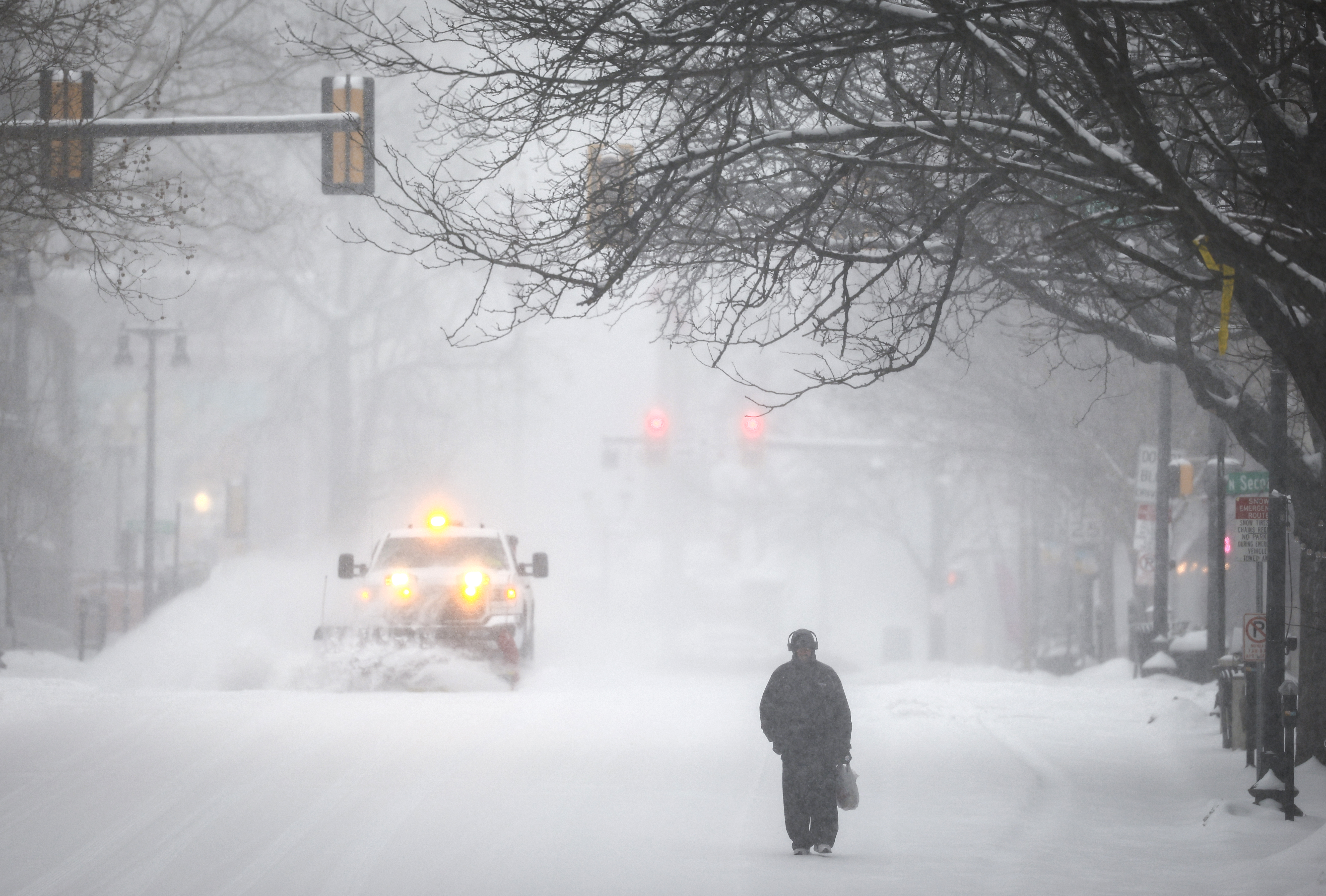 Josh Brown, of Easton, walks down Northampton Street on his way home from shopping as a plow truck clears snow Sunday, Jan. 25, 2026.