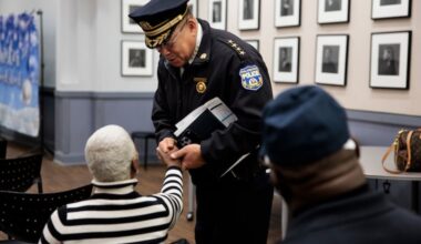 Police Commissioner Kevin Bethel greets Pamela Chase, Director of the Group Violence Intervention program, before a community meeting at a church in the 22nd Police District in December.
