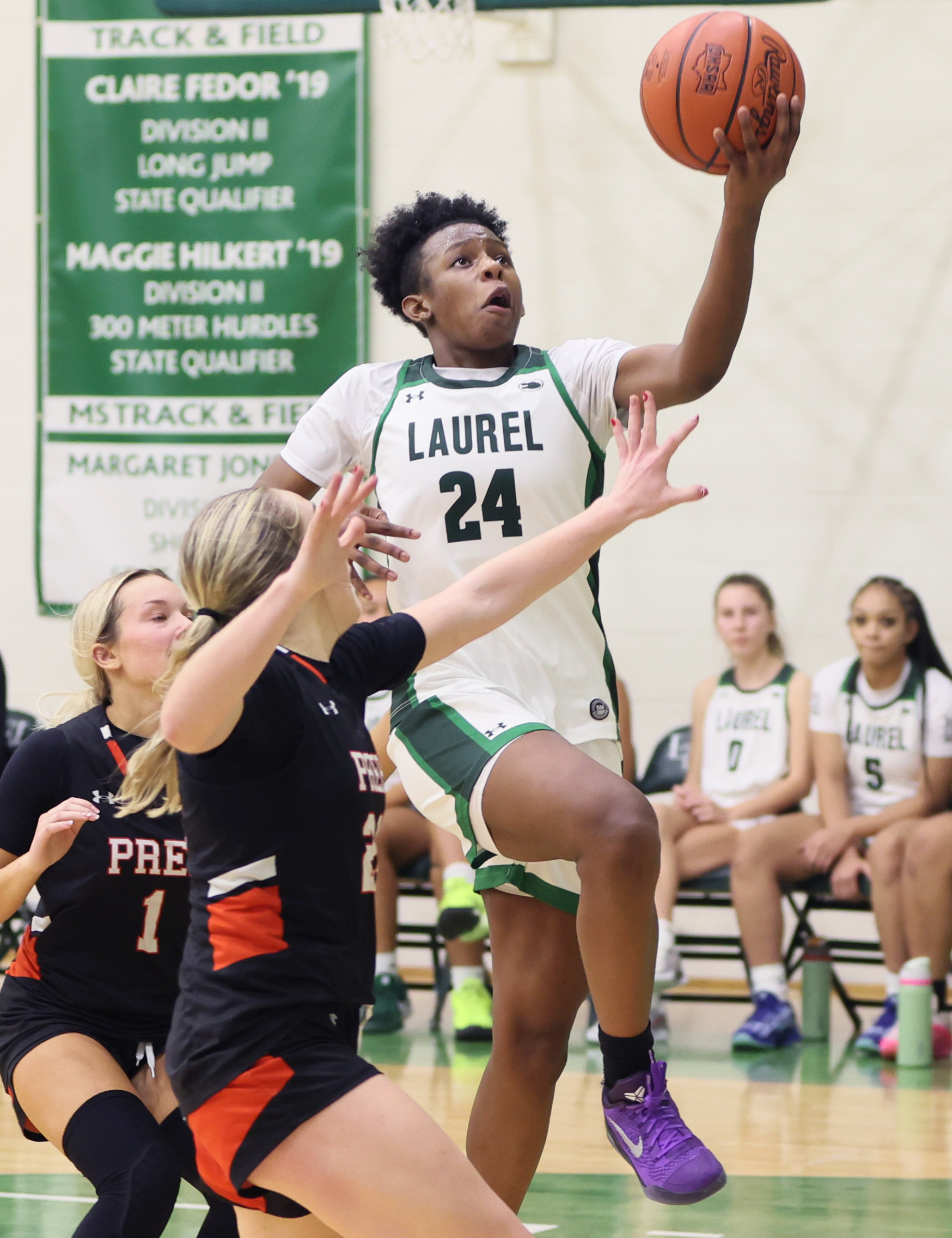 Laurel's Tristan Williams drives to the basket for a score guarded by Cathedral Prep's Mia Washburn in the second half.  