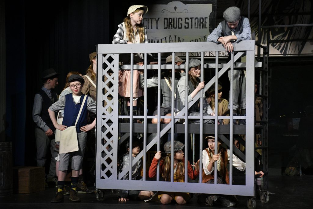 students performing in costume on stage