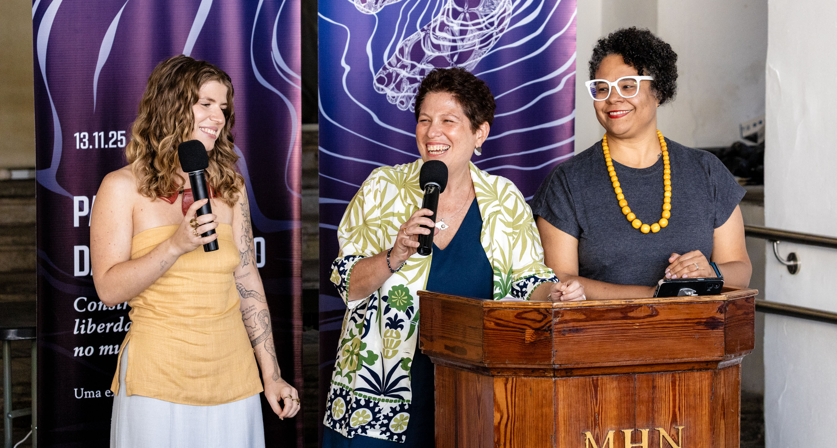 Three women at a podium