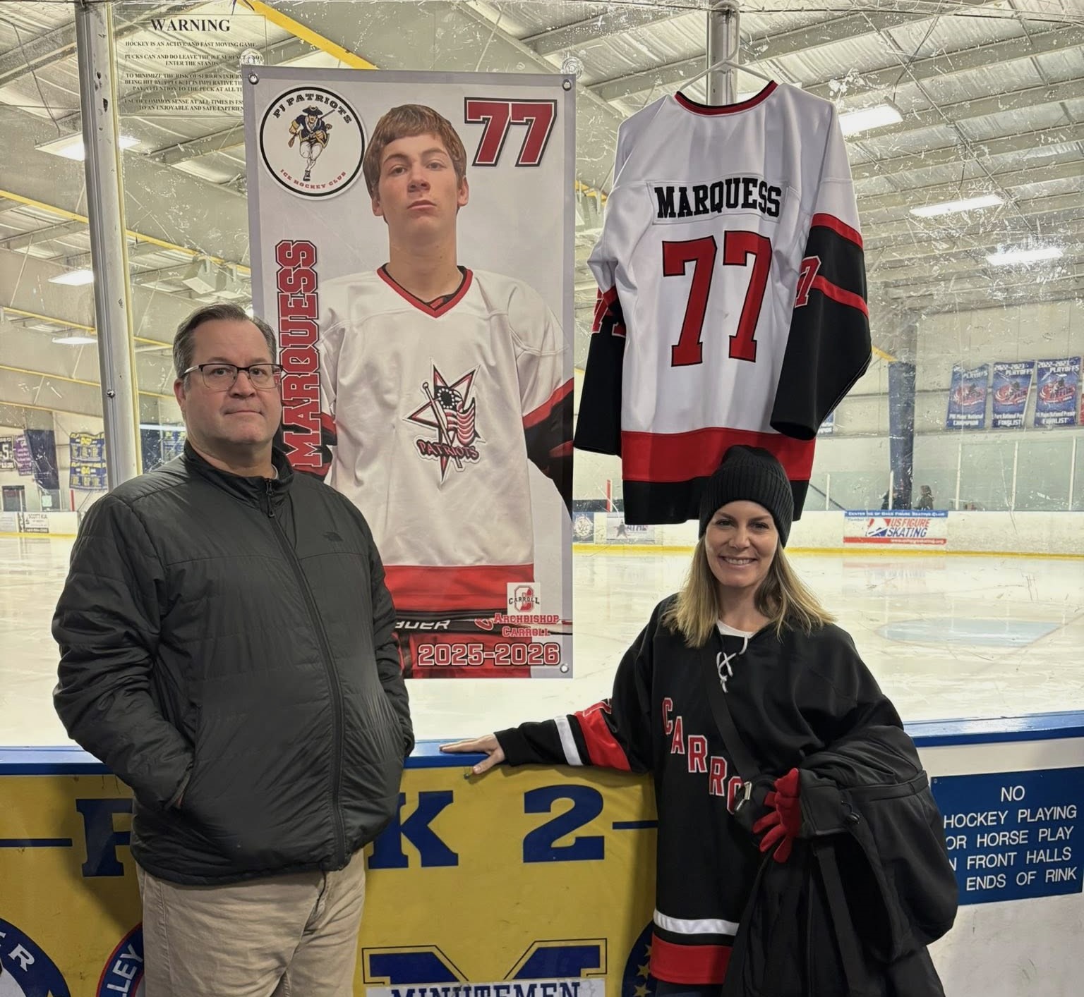 Matt and Danielle Marquess pose next to a huge portrait...