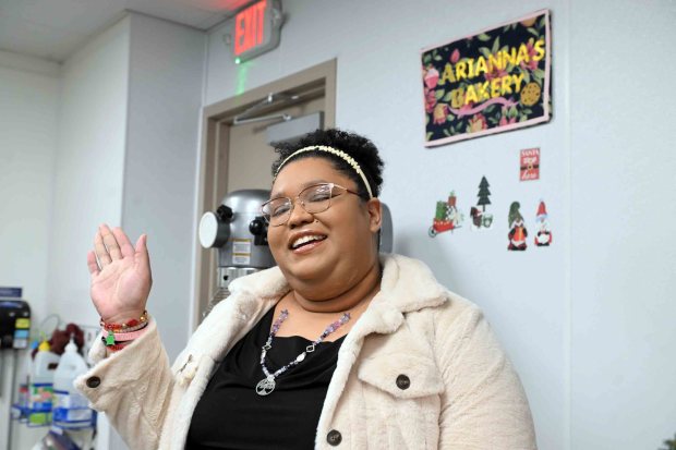 Arianna Austin embellished a sign from a bakery with artwork, noting her love of baking for Opportunity House, where she is staying while attending Albright College. (BILL UHRICH/READING EAGLE)