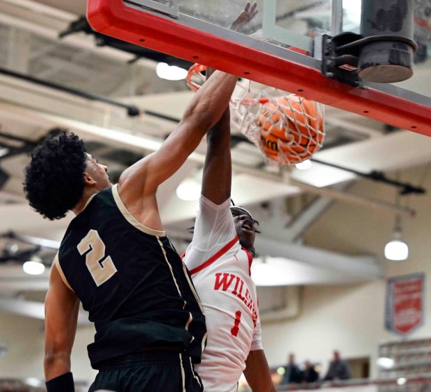 Berks Catholic's Kingston McKoy victory dunks over Wilson's Peter Kelfalla for two of his game-high 22 points in a 50-38 Saints' victory over the Bulldogs on Monday, Jan. 19, 2026, at West Lawn. (BILL UHRICH/READING EAGLE)