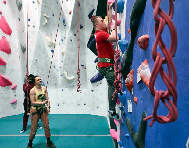 Krista Weller belays Kyle Wolf as he climbs the rock wall during an IM ABLE foundation adaptive rock climbing session at Reading Rocks Climbing and Fitness, 550 George St., Muhlenberg Township. (BILL UHRICH/READING EAGLE)