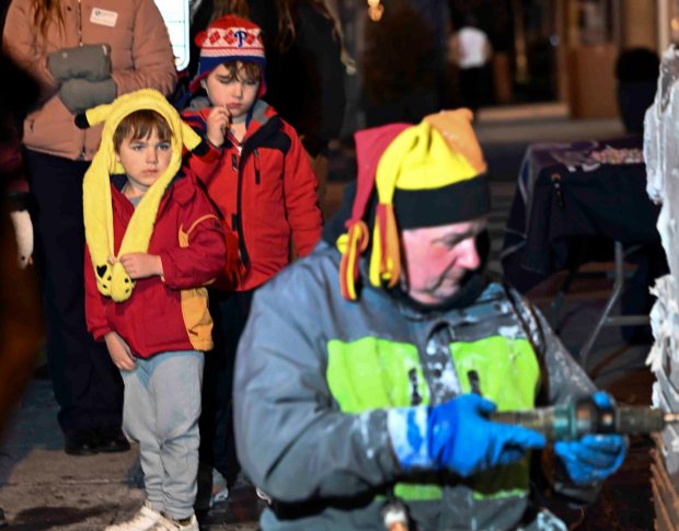 Children watch Danny Kissel of Shippensburg carve a Nittany Lion at the Ice and Spice Festival in West Reading on Friday, (BILL UHRICH/READING EAGLE)