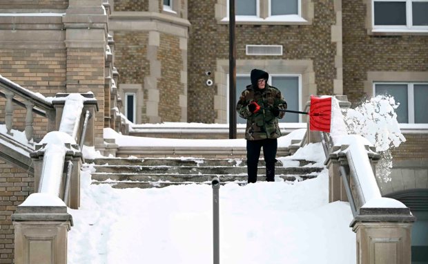 A Reading School District maintenance worker shovels the front steps of Reading High School on Monday, Jan. 26, 2026. (BILL UHRICH/READING EAGLE)