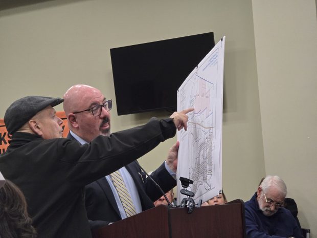 Bell Mountain resident Tim Pfleiderer, left, points out his home to Attorney Raymond Rinaldi, who represented the data center developer, during a public hearing Tuesday, Jan. 20, 2026, in the Dickson City Borough Building. (FRANK WILKES LESNEFSKY / STAFF PHOTO)
