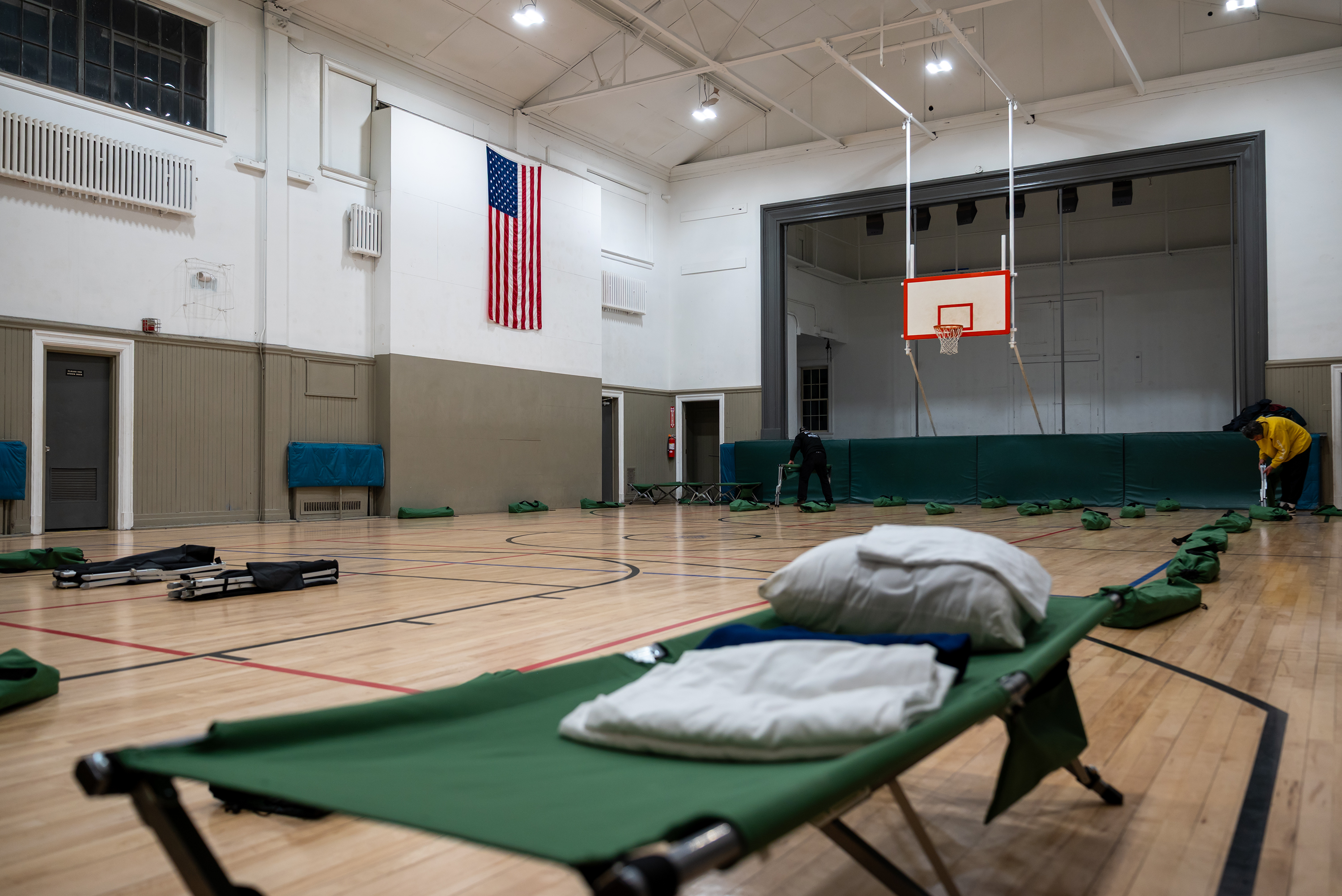Staff members and volunteers set up cots at Weston Field...