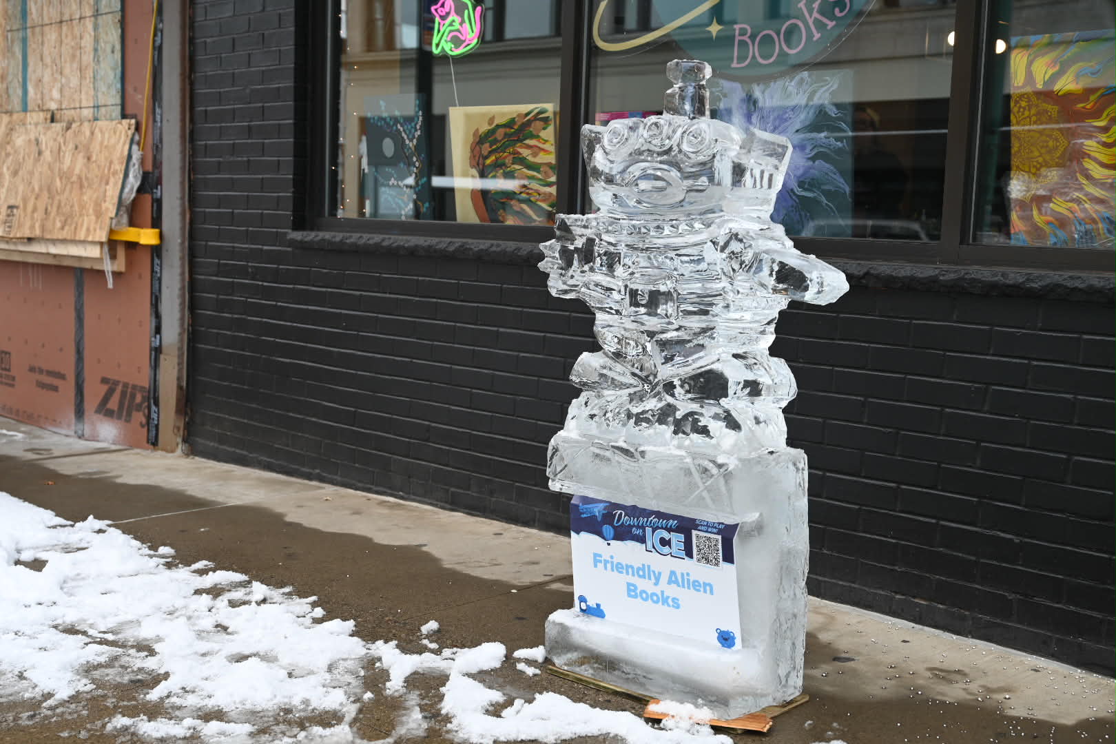 A sculpture of the alien from Toy Story sits outside...