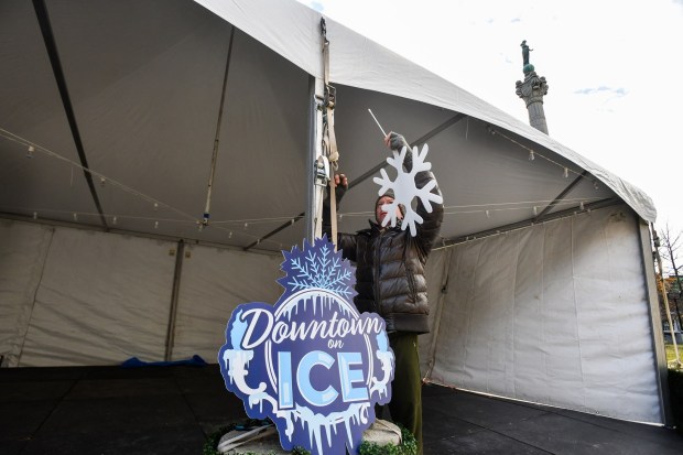 Scranton Tomorrow board member Joshua Mast attaches snowflakes to the main tent on N. Washington Ave. in downtown Scranton Friday, January 16, 2026. (SEAN MCKEAG / STAFF PHOTOGRAPHER)