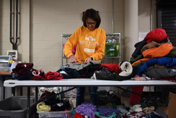 Volunteer Lynn Gavin sorts donations during the children's clothing drive at the St. Joseph Center in Dunmore, Jan. 16, 2026. Gavin retired from the center last year. She wanted to help out again this year after seeing the joy families get from receiving needed items. (REBECCA PARTICKA/STAFF PHOTOGRAPHER)