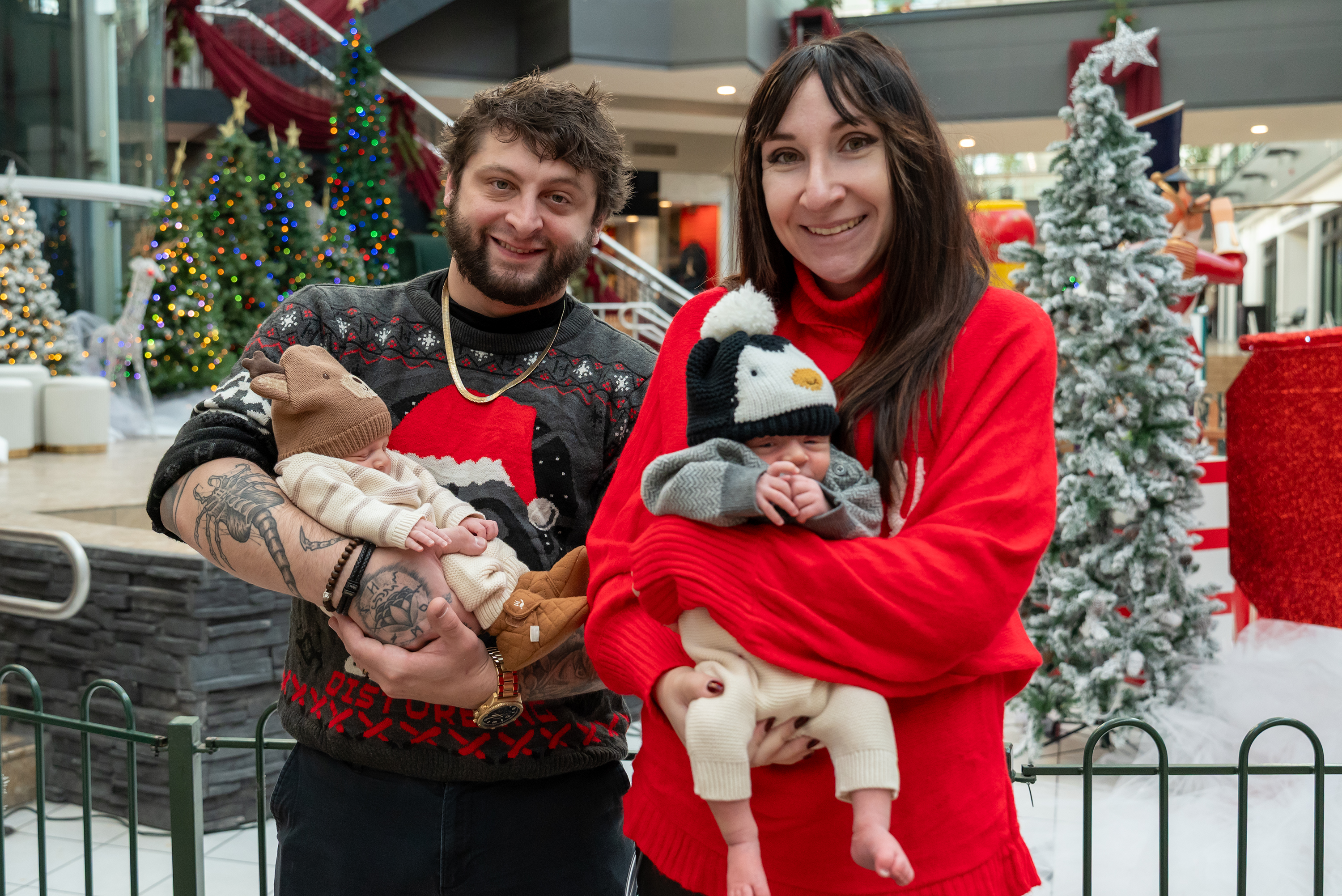 Zach and Alyssa Meighan hold their twin sons Myles and...