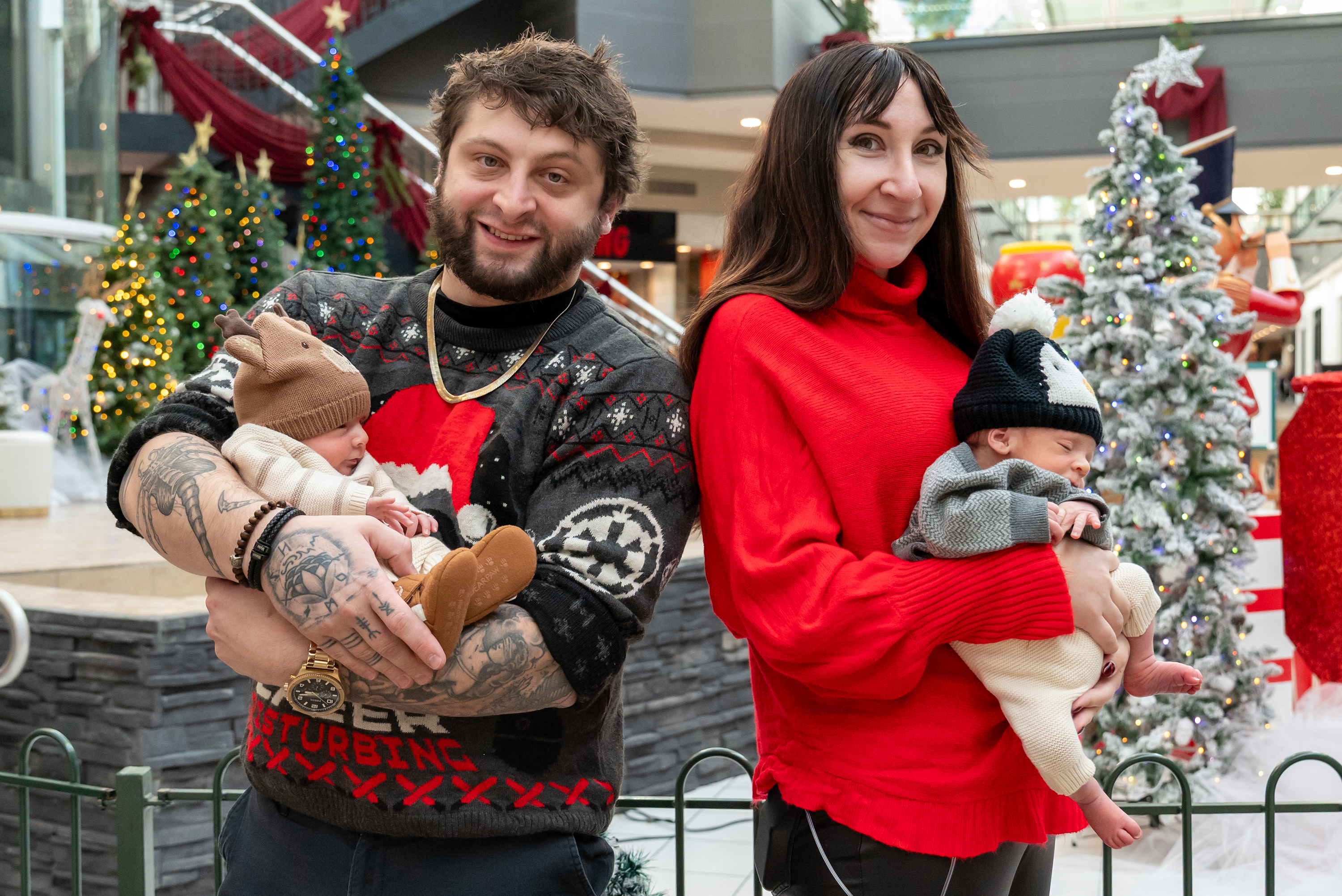 Zach and Alyssa Meighan hold their twin sons Myles and...