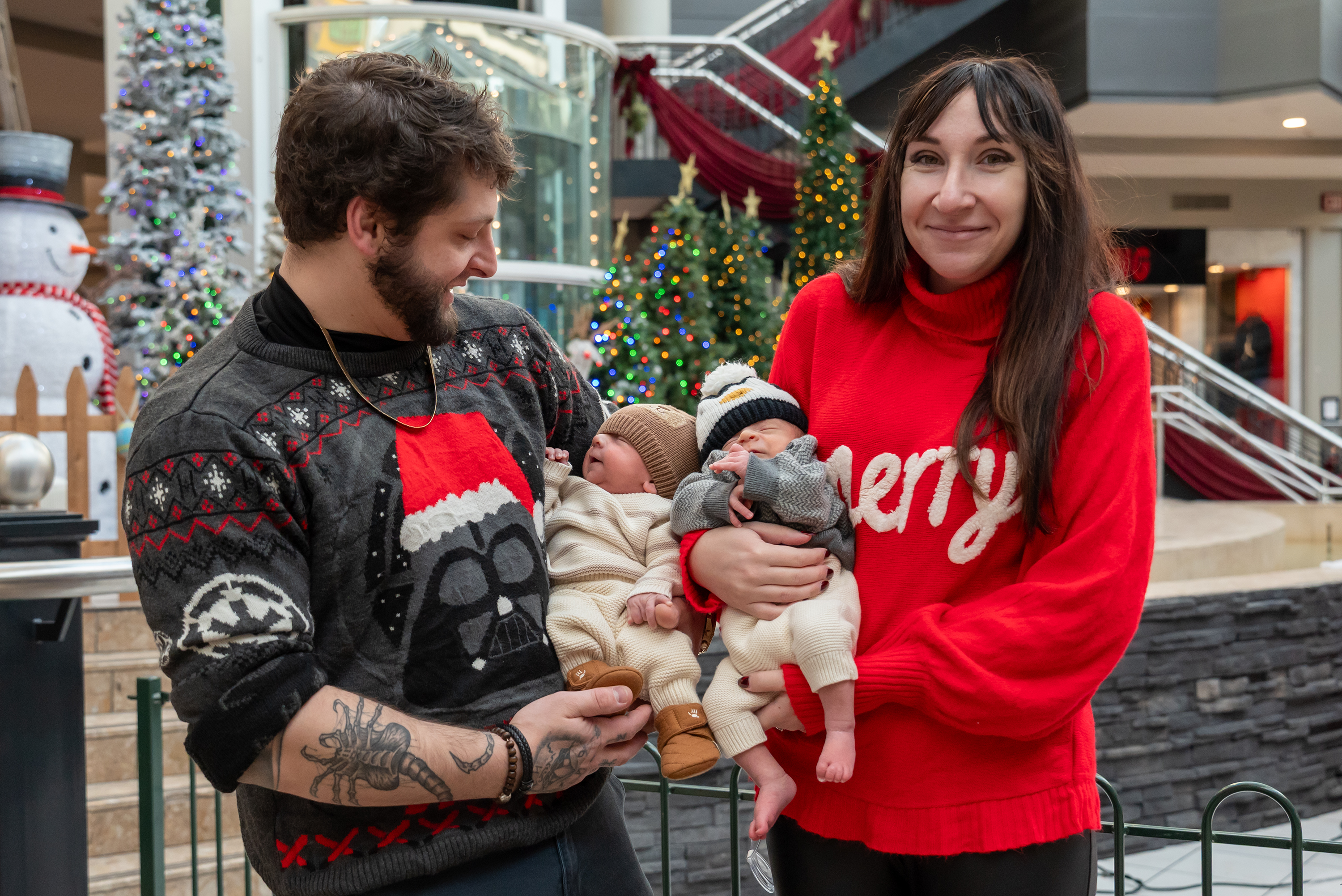 Zach and Alyssa Meighan hold their twin sons Myles and...