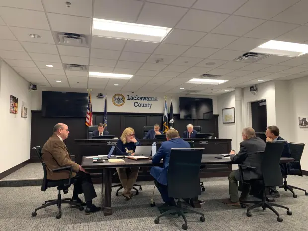 The Lackawanna County Commissioners, on dais from left, Bill Gaughan, Chris Chermak and Thom Welby, at a meeting on Dec. 30, 2025. (JIM LOCKWOOD / STAFF PHOTO)