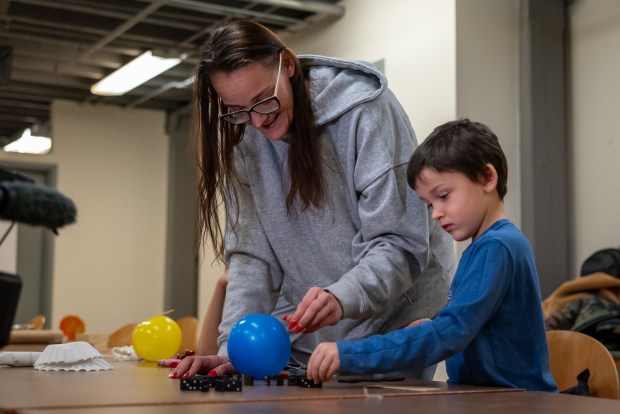 Ashley Colewell helps her son kindergartner Giovanni Mac set up dominoes for the Reach Cyber Charter School's winter STEM challenge at the Electric City Trolley Museum in Scranton on Wednesday, Jan. 14, 2026. (REBECCA PARTICKA/STAFF PHOTOGRAPHER)