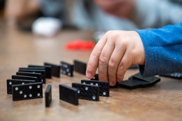 Kindergartner Giovanni Mac set up dominoes for the Reach Cyber Charter School's winter STEM challenge at the Electric City Trolley Museum in Scranton on Wednesday, Jan. 14, 2026. (REBECCA PARTICKA/STAFF PHOTOGRAPHER)
