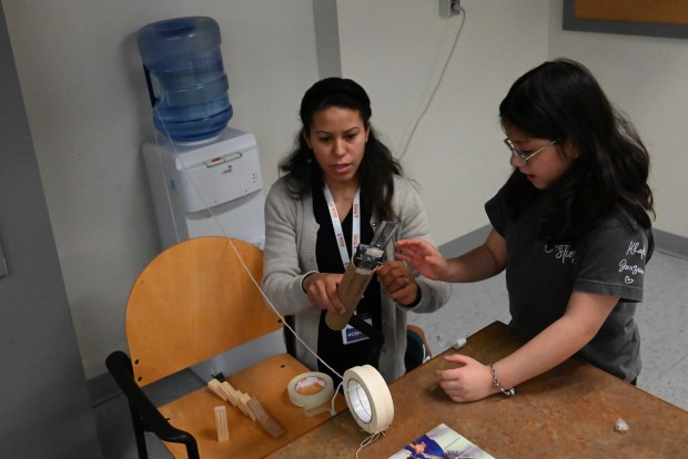 Robotics coordinator Karen Mcgahee helps third grade student Khali Garcia for the Reach Cyber Charter School's winter STEM challenge at the Electric City Trolley Museum in Scranton on Wednesday, Jan. 14, 2026. (REBECCA PARTICKA/STAFF PHOTOGRAPHER)