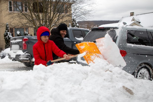 Francisco Tiburcio and his son Carlos Alberto shovel snow along Irving Ave. in Scranton on Monday, Jan. 26, 2026. (REBECCA PARTICKA/STAFF PHOTOGRAPHER)