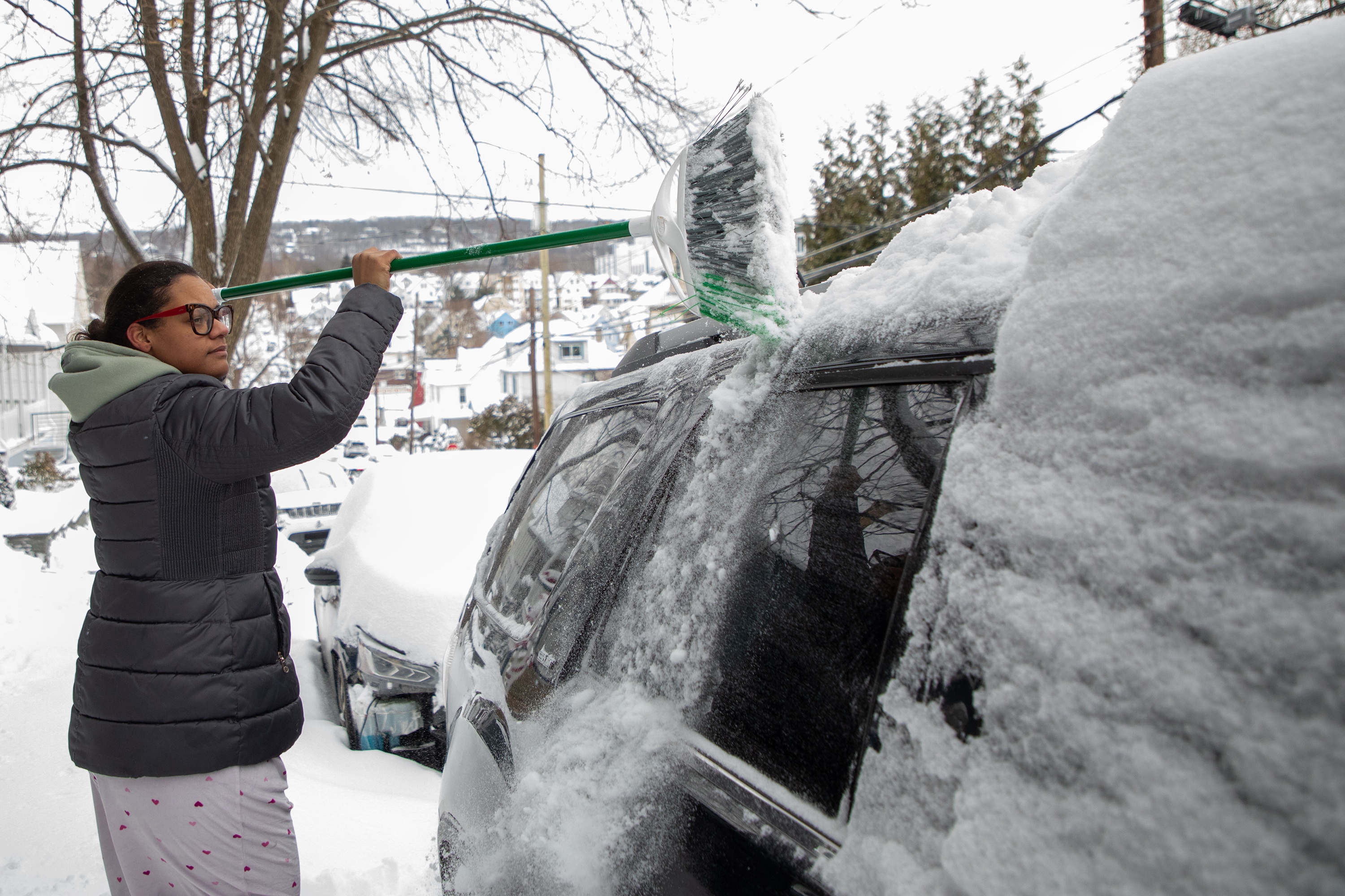 Freisi Colon cleans off her vehicle parked along Vine St....