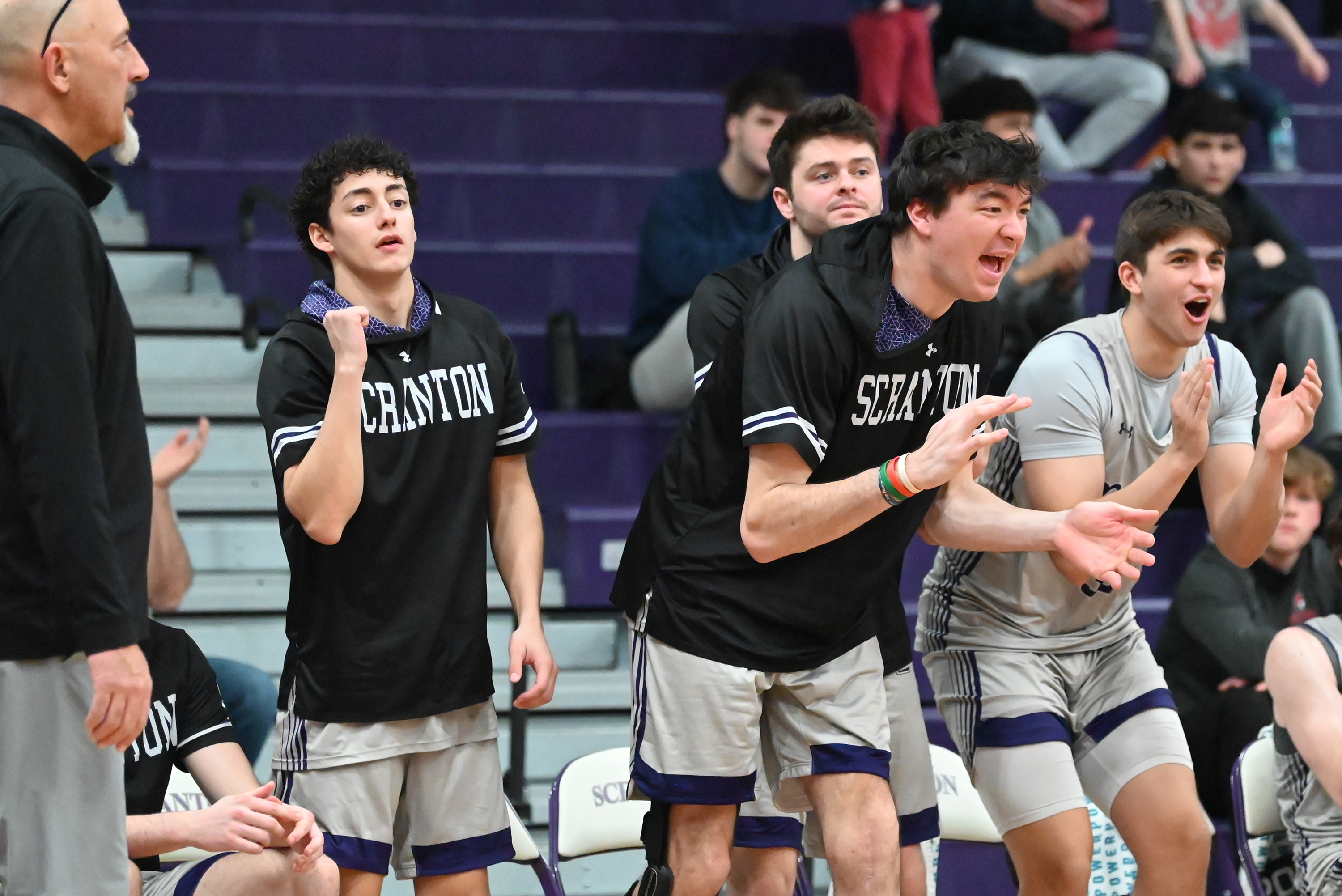 University of Scranton players on the bench celebrate as their...