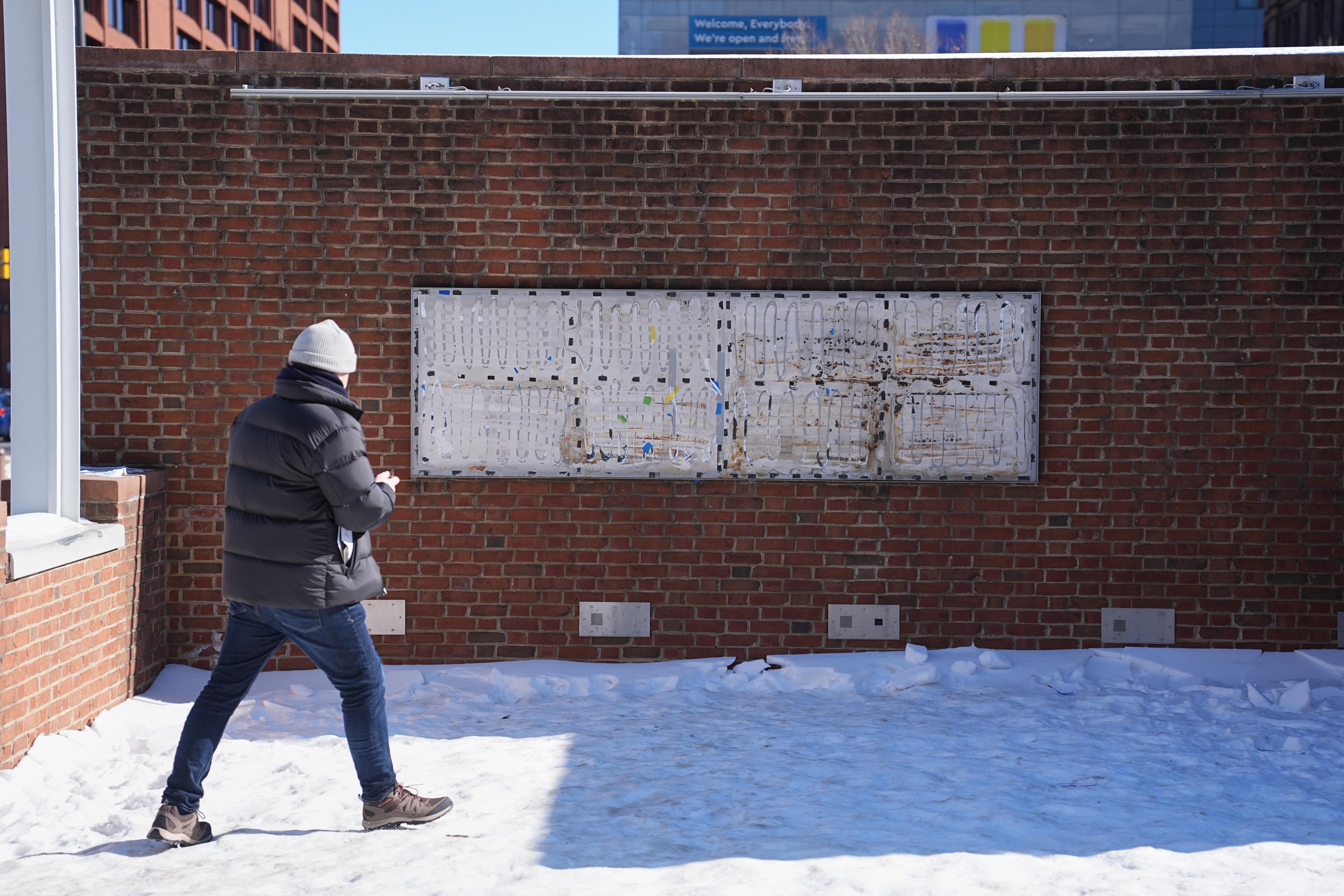 A person moves to photograph the location of the now...