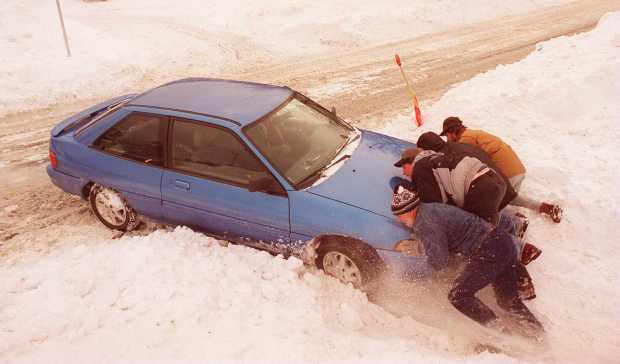 When Mickey Marquart got his car stuck trying to enter the Quaker Village Shopping Center from Branch Street, he borrowed a shovel from a merchant and, after some shoveling, passersby stopped to help push him out. Photo taken Jan. 9, 1996. (Doug Benedict/The Morning Call)