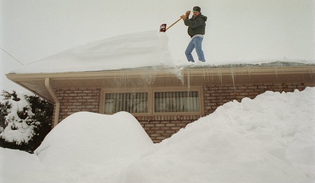 Paul Reid cleans a ton of snow off his roof at the corner of North Glenwood and Tilghman streets in Allentown on Jan. 9, 1996. (Tom Volk/The Morning Call)