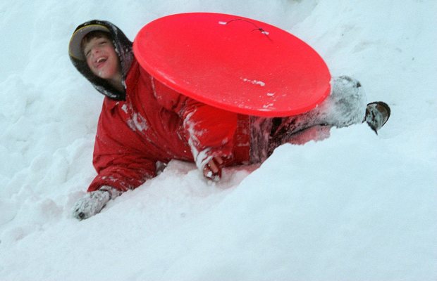 Zachary Wikane, 11, of Emmaus, wipes out while snow saucer-sliding down a huge pile of snow left by snowplows in the Rodale Press parking lot on North Sixth Street in Emmaus after the blizzard of 1996, Jan. 9, 1996. (Betty E. Cauler/The Morning Call)