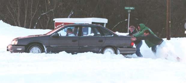 Three men help a motorist out in the snow by pushing it though a snowbank on Fullerton Avenue, Jan. 8, 1996. (John C. Anderson/The Morning Call)