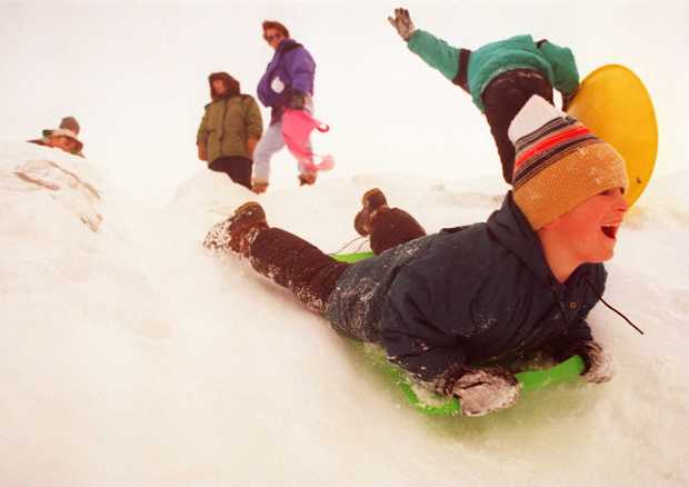 Dustin Weisel of Quakertown takes a steep slide down a snow mountain created by crews removing snow from the streets and dumping it in the parking lot of the Quakertown Municipal Pool during the blizzard of 1996. (Doug Benedict/The Morning Call)