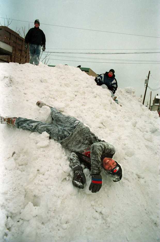 LaMarr Watson, 15, finds himself rolling down a hill of snow during a game of 'king of the mountain' with friends along Long and Raspberry streets in Bethlehem after the blizzard of 1996, Jan. 9, 1996. (Dan DeLong/The Morning Call)