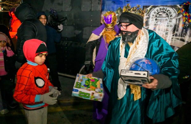 Playing a king Ricardo Quiles hands a present to Isaias, 7, Wednesday, Jan. 8, 2025, during a Three Kings Day celebration at Lights in the Parkway in Allentown. Three Kings Day, or Epiphany, commemorates the magi's visit to the baby Jesus. It's celebrated Jan. 6, but the local celebration was delayed because of Monday's snow.(April Gamiz/The Morning Call)