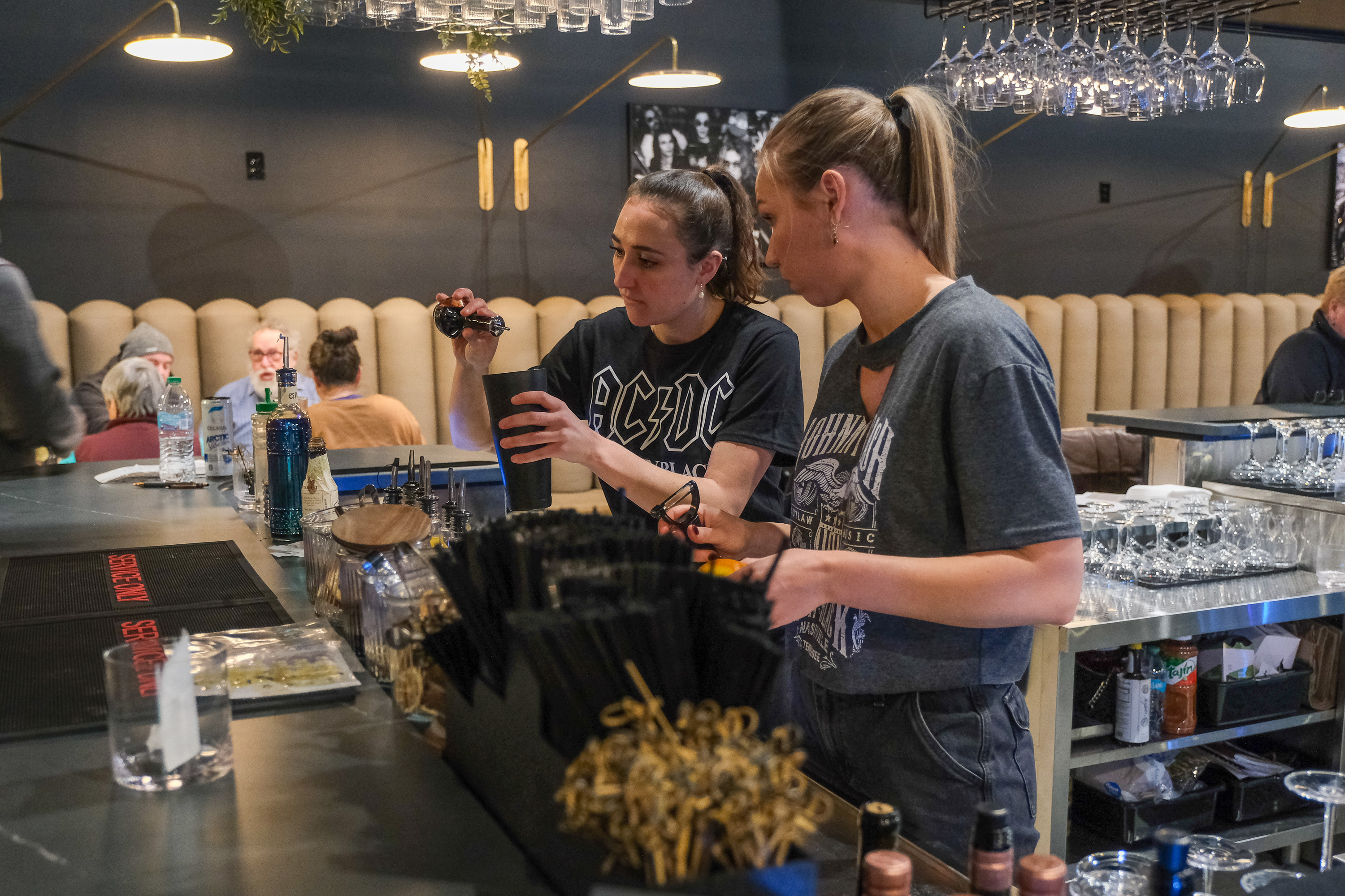 Riley Baughman, left, mixes a drink as fellow bartender Alyssa...