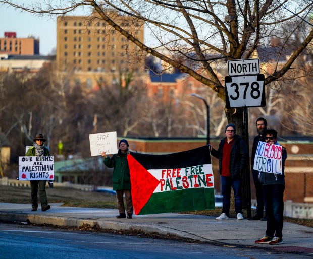 Protesters hold signs as vehicles drive past Thursday, Jan. 8, 2026, in Bethlehem. Organizers with the Lehigh Valley Democratic Socialists of America and LEPOCO Peace Center protest for causes including against the recent U.S. military action in Venezuela. (April Gamiz/The Morning Call)