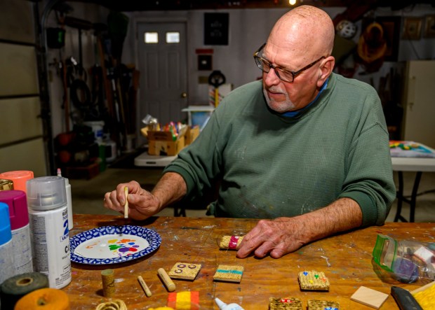 Dave Jacoby of Bethlehem Township paints experimental art on tiles Tuesday, Jan. 6, 2026, in Bethlehem Township. As part of an idea he had years ago that he calls WOA! (World of art!), Jacoby leaves the tiles in various place to cheer up people at a time when there is fear, anger and sadness in the world. He started a Facebook page and gives the tiles to people, asking them to spread the art and upload a photo and a post about where it was placed. (April Gamiz / The Morning Call)