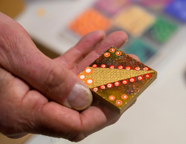 An experimental art tile Tuesday, Jan. 6, 2026, created by Dave Jacoby of Bethlehem Township as part of an idea he had years ago that he calls WOA! (World of art!). Jacoby leaves the tiles in various place to cheer up people at a time when there is fear, anger and sadness in the world. He started a Facebook page and gives the tiles to people, asking them to spread the art and upload a photo and a post about where it was placed. (April Gamiz / The Morning Call)