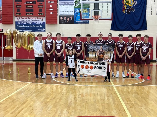 Lehighton senior Cole Dietz, holding a banner with his picture, is surrounded by his teammates in a postgame ceremony after reaching 1,000 points in his career. Dietz was named MVP and scored 31 in leading the Indians to a win over Northern Lehigh in the Hamburg Tip-Off Tournament Saturday night. (Contributed photo Louann Dietz)