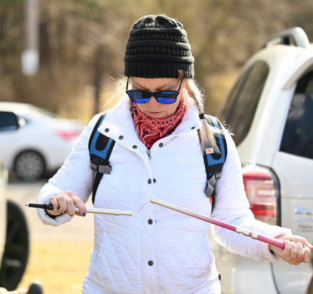 Sharon Carpenito gets her hiking poles ready before joining the other members of Lehigh Valley Women of Adventure on a hike Sunday, March 5, 2023, at the Wildlands Conservancy South Mountain Preserve in Emmaus. (Amy Shortell/The Morning Call)