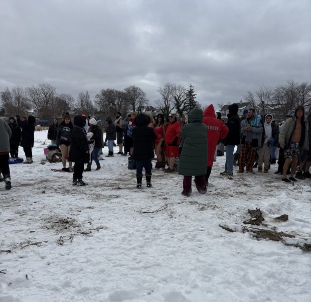 People pose for pictures as they wait to test the frigid waters of Lake Erie as part of the 'Port Plunge at Fairport Harbor Lakefront Beach on Jan. 1. (William Tilton - News-Herald)