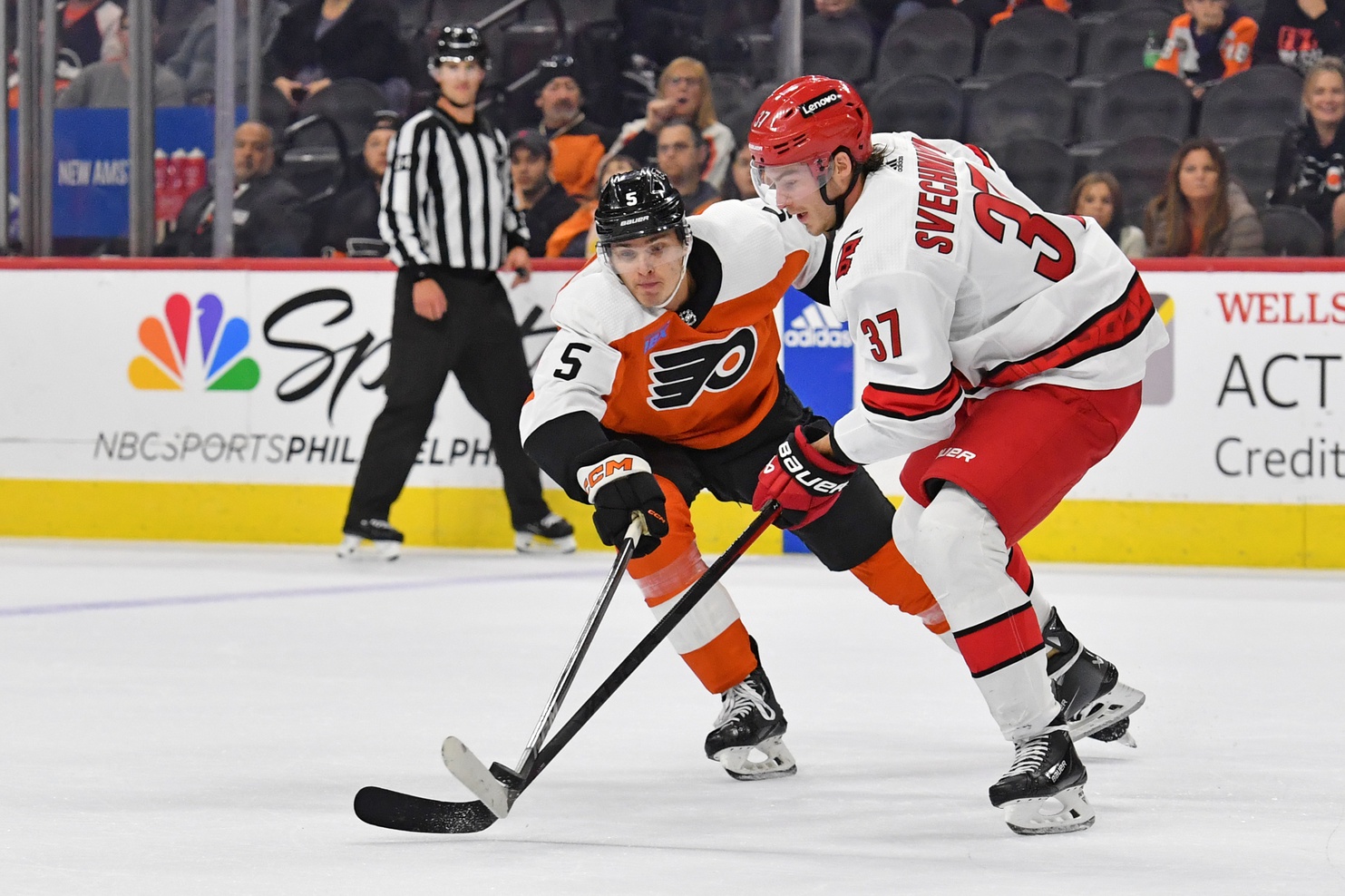 Oct 30, 2023; Philadelphia, Pennsylvania, USA; Philadelphia Flyers defenseman Egor Zamula (5) and Carolina Hurricanes right wing Andrei Svechnikov (37) battle for the puck during the third period at Wells Fargo Center.